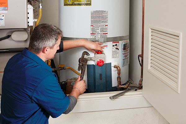 Certified plumber servicing a residential water heater